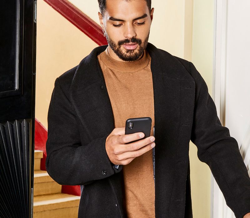 Mann steuert Rollläden per Smartphone